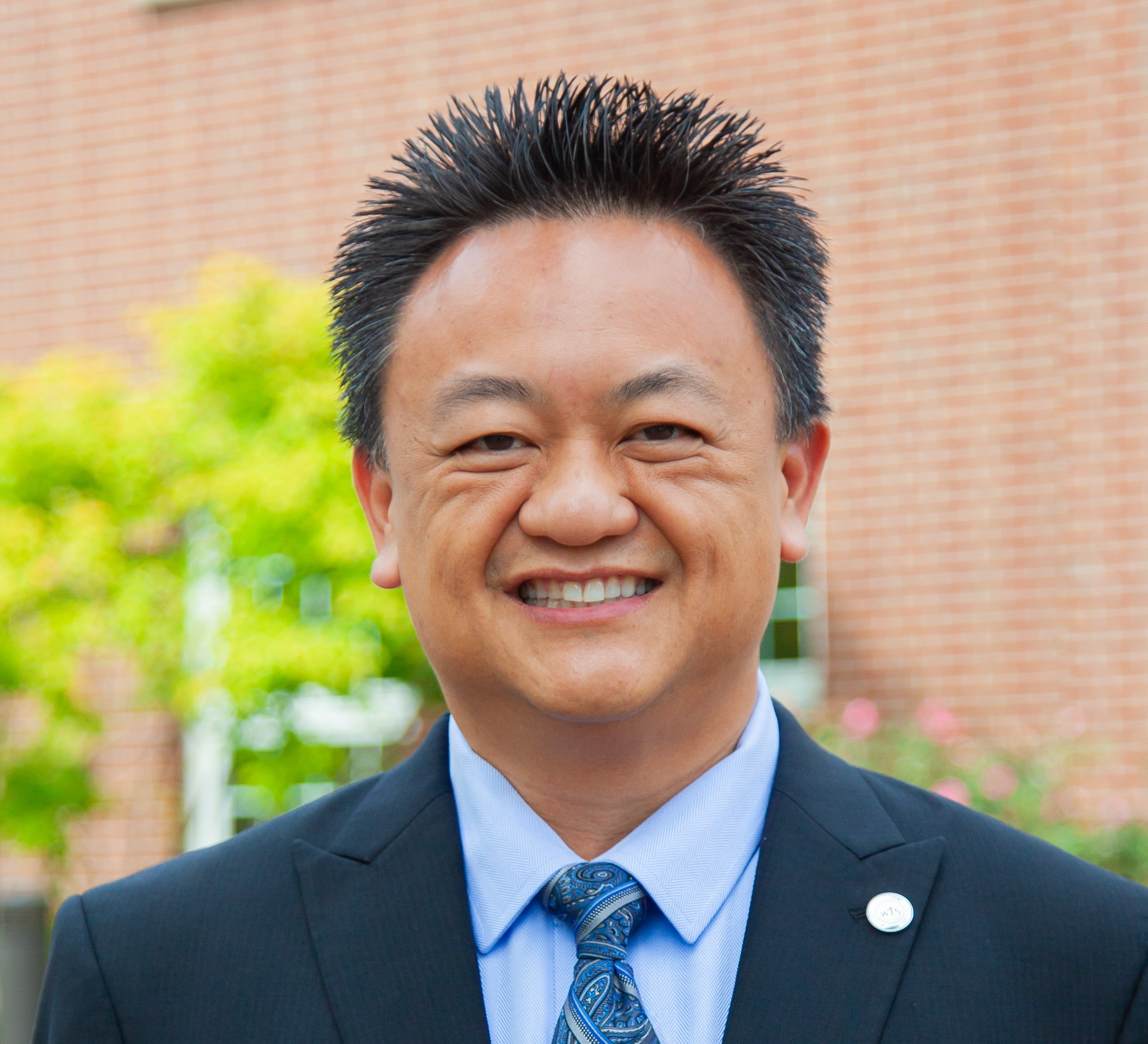 Man smiling at camera in suit.